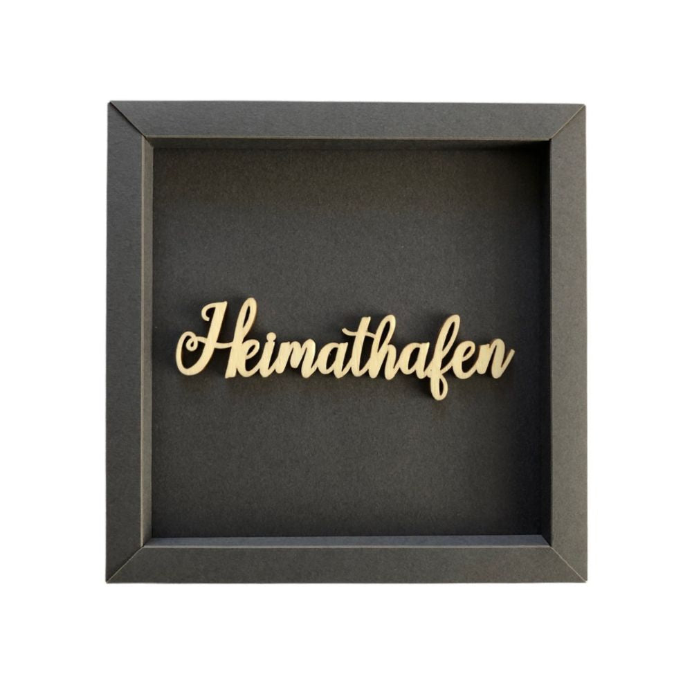 Quadratische Wanddekoration in Dunkelgrau mit der Schrift "Heimathafen"