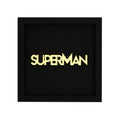 Quadratische Schwarze Wanddekoration mit dem Spruch "Superman" in Hellgelb