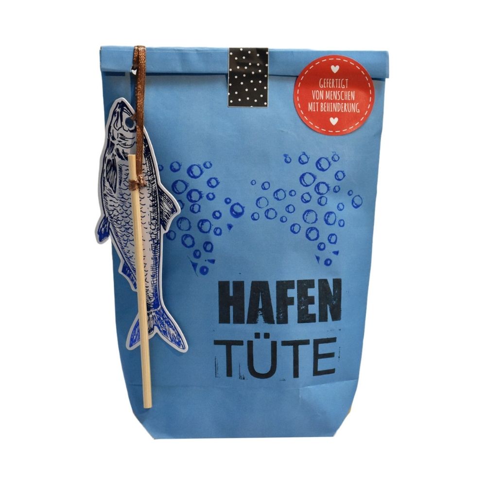 Blaue Wundertüte mit kleinen Luftblasen und der Schrift "Hafen Tüte" und einem angehangenen Papier Fisch mit einem kleinen Stock