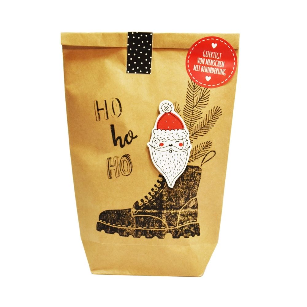Braune Wundertüte mit der Schrift "Ho ho ho" und einem schwarzen Stiefel aus dem ein Nikolaus guckt