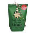 Grüne Wundertüte mit einem angehangenen hölzernen Stern und einem schmalen Bändchen auf dem klein steht "Frohe Weihnachten" und unter dem Stern steht in schwarzer Schrift "Greif einfach nach den Sternen"