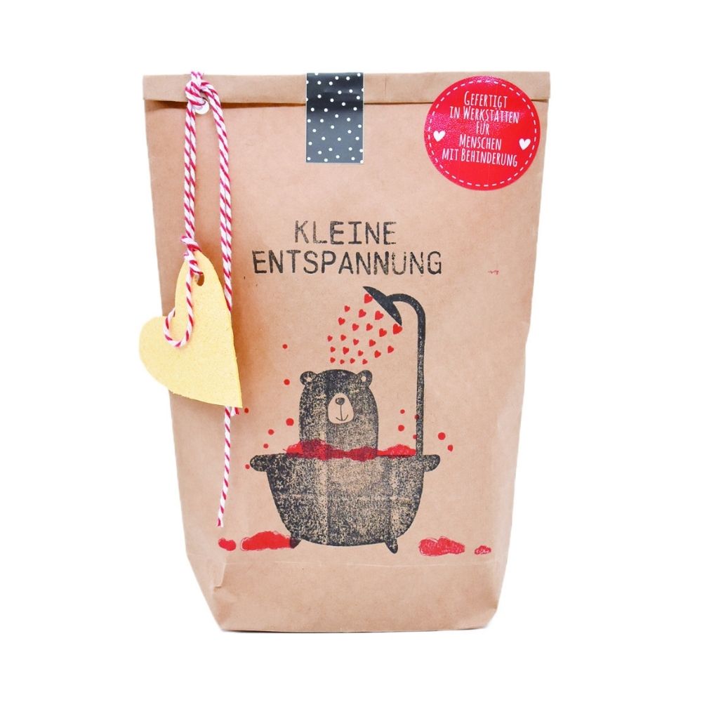 Braune Wundertüte mit einem aufgedruckten Bär, der in einer Badewanne voll herzchen Badet aus dem Duschkopf kommen auch kleine Herzchen herraus