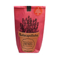 Rote Wundertüte mit einem aufgeklebten Topf auf dem "Naturaphotheke Pflanzset Lavendel" steht und aufgedrucktem Lavendel das aus dem Topf wächst