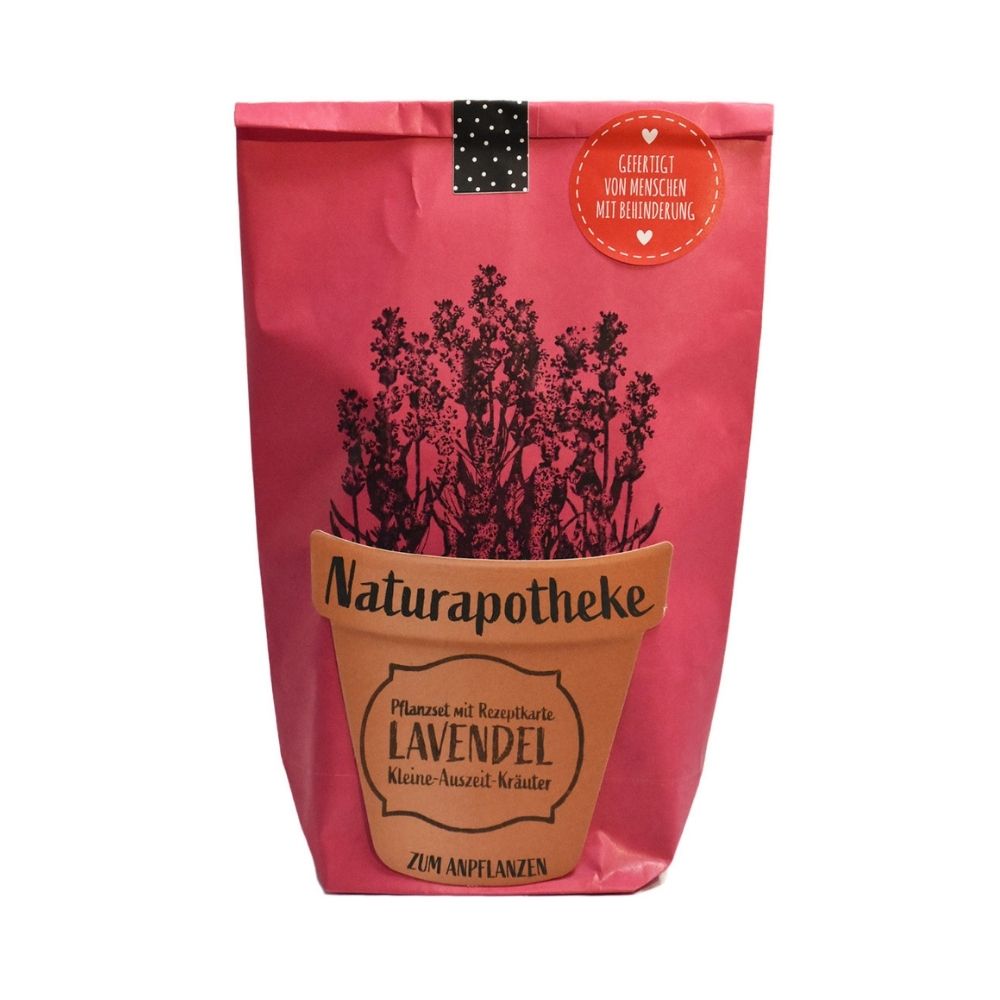 Rote Wundertüte mit einem aufgeklebten Topf auf dem "Naturaphotheke Pflanzset Lavendel" steht und aufgedrucktem Lavendel das aus dem Topf wächst