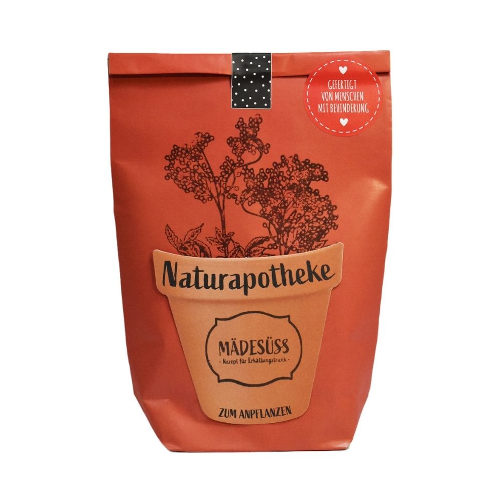 Rote Wundertüte mit einem aufgeklebten Tontopf und der Schrift "Naturapotheke" "Mädesüss" und aufgedruckten Kräutern die aus dem topf "wachsen"