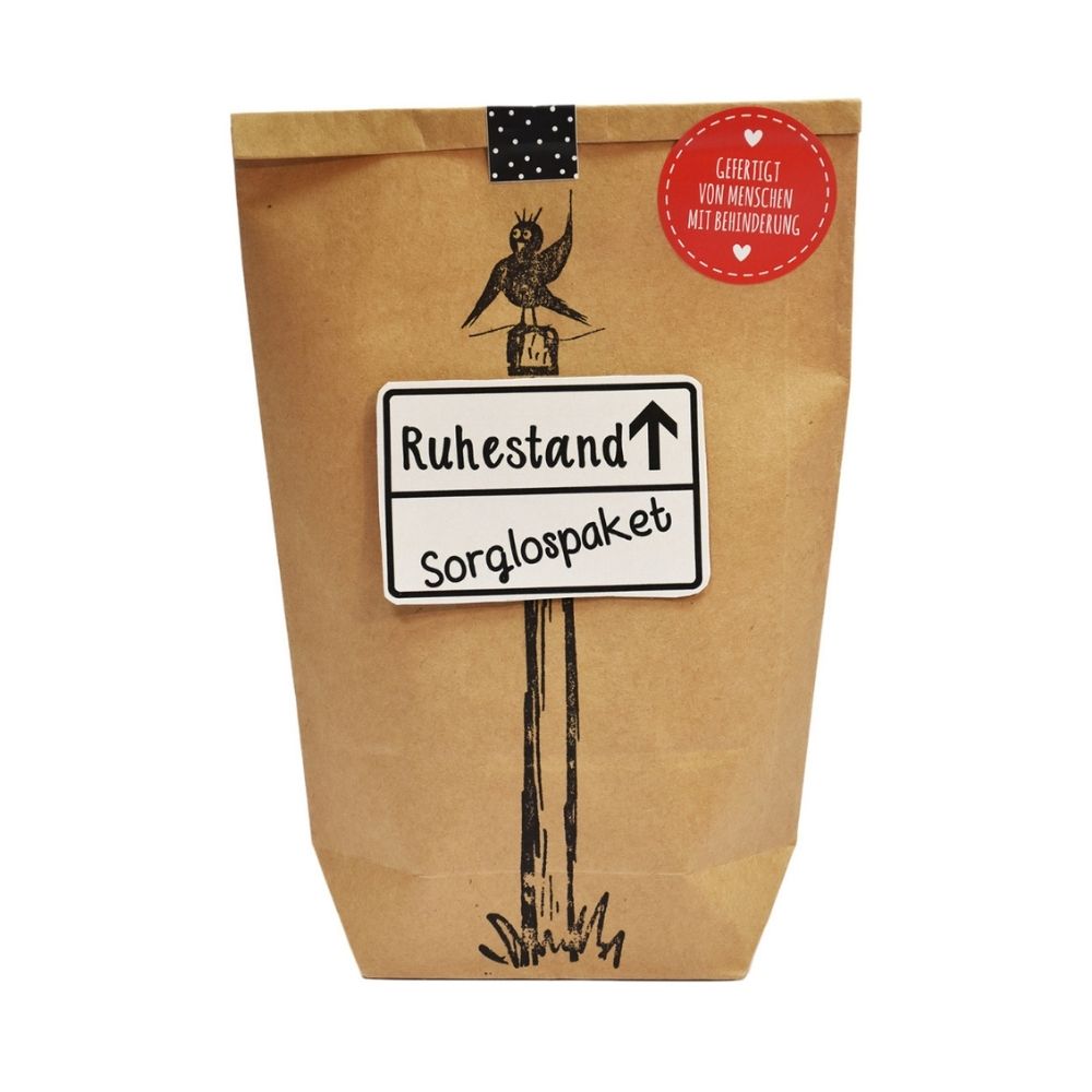 Braune Wundertüte mit einem angedruckten Pfahl auf dem ein Vogel sitzt an der Tüte ist ein Ortsschild mit der Schrift "Ruhestand/ Sorglospacket" befestigt