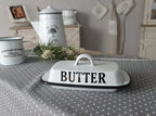 weiße Butterdose mit der schwarzen Schrift "BUTTER" auf einem Tisch
