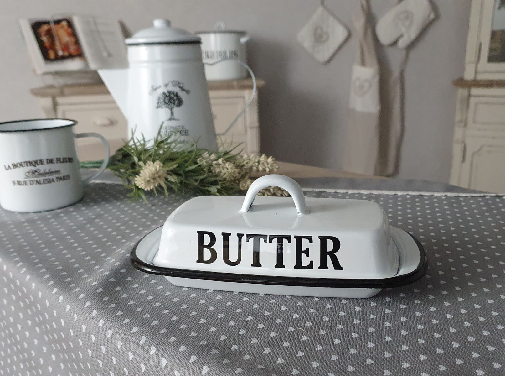 weiße Butterdose mit der schwarzen Schrift "BUTTER" auf einem Tisch