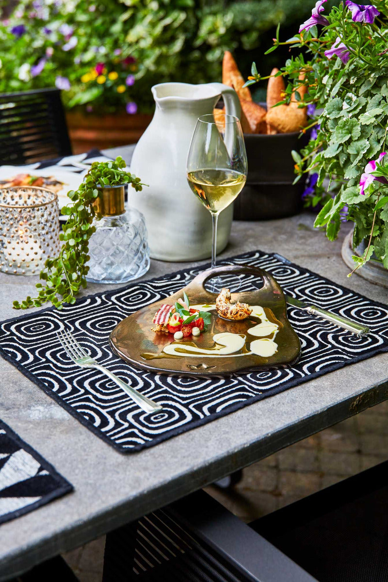 Weiße Designer Keramik Karaffe mit unebenen Flächen draußen auf einem gedeckten Tisch