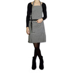 Frau trägt Schwarz/Weiß karierte Kord-Schürze