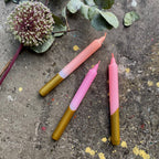 Drei Stabkerzen etwas auseinander auf einem steinernen Untergrund