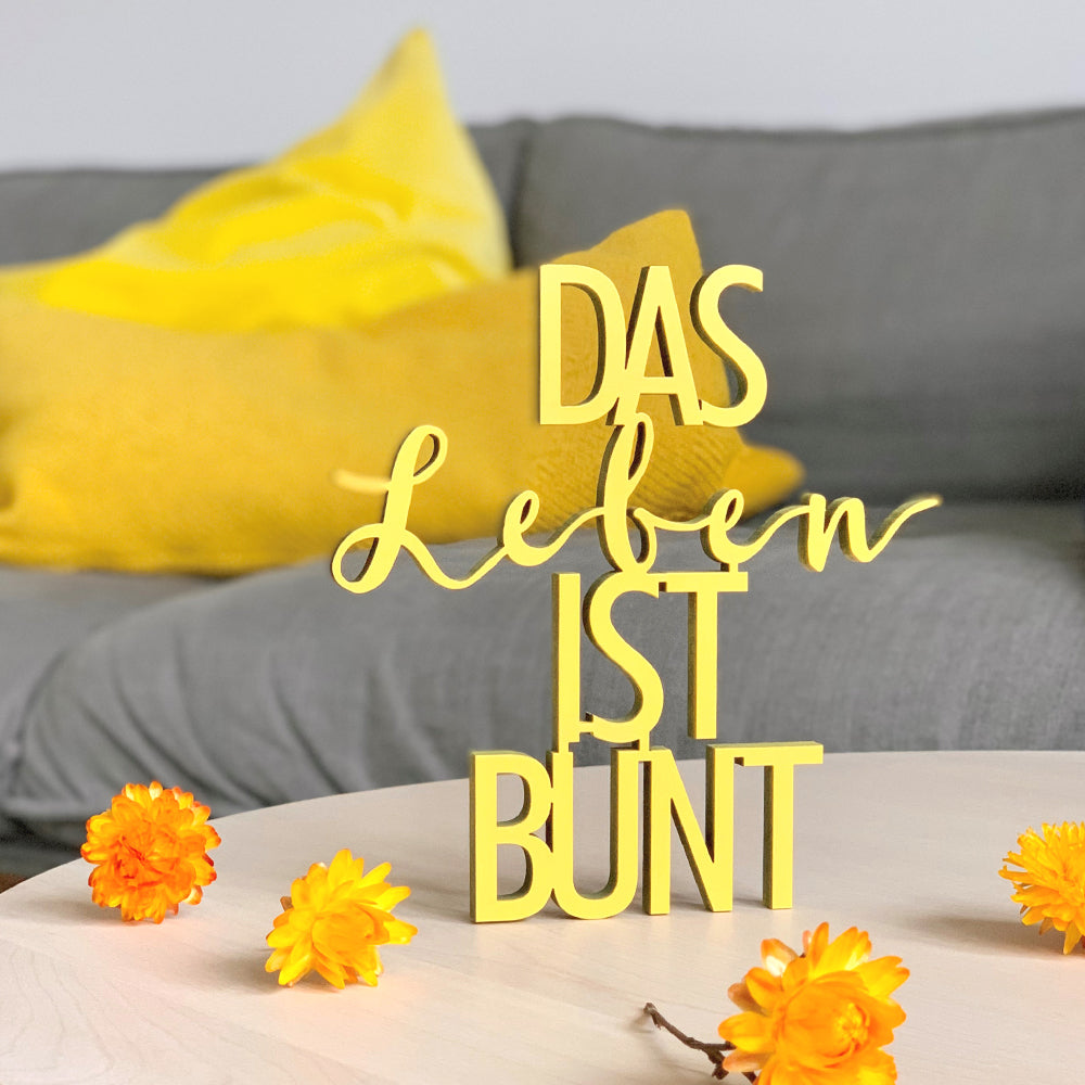 Gelb Dekorations Holzschriftzug mit dem Text "Das Leben Ist Bunt"