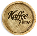 Eingekerbter Holzuntersetzer mit dem aufgedruckten Spruch „Kaffee Pause"
