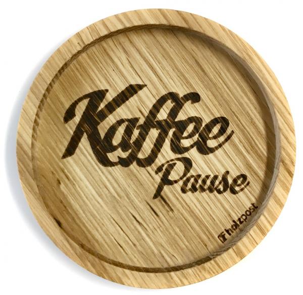 Eingekerbter Holzuntersetzer mit dem aufgedruckten Spruch „Kaffee Pause"