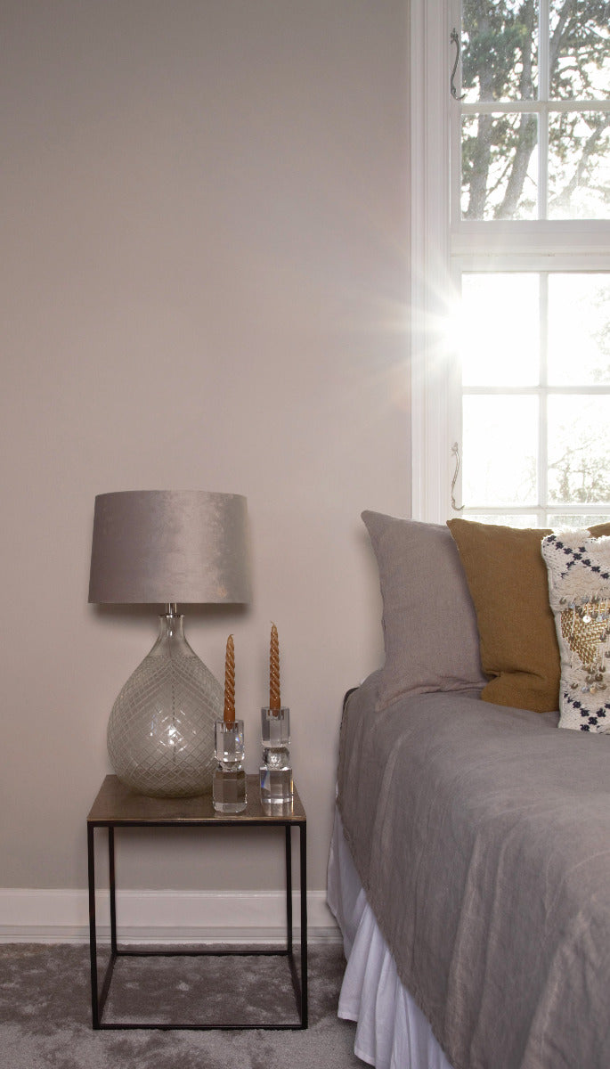 Die klaren Kristallhalter in einem Schlafzimmer auf dem Bestelltisch mit Braunen Stabkerzen und einer Lampe