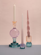 Verschiedene Kerzenhalter in gleichen farbtönen auf dem Tisch mit enthaltenen Stabkerzen