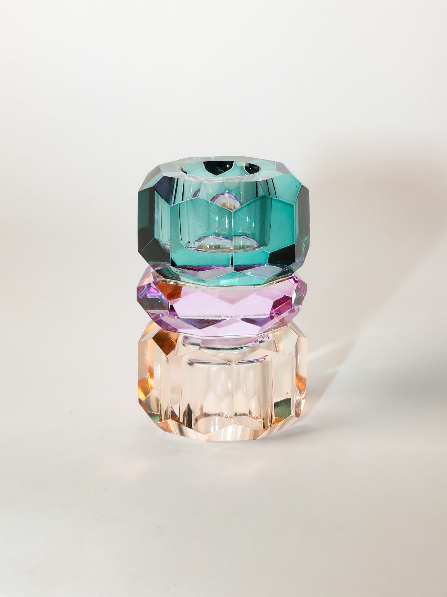 Ein hoher wendbarer Dioptrics Kerzenhalter aus Glas in Petrol, Violett und Pfirsich Kristall-Optik, bestehend aus mehreren geometrischen Flächen. Der Kerzenhalter hat eine moderne, facettierte Optik, die das Licht reflektiert, umgedreht