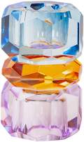 Ein hoher Kerzenhalter aus Glas in Violett, Kobalt und Bernstein Kristall-Optik, bestehend aus mehreren geometrischen Flächen. Der Kerzenhalter hat eine moderne, facettierte Optik, die das Licht reflektiert.