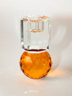 Ein hoher Dioptrics Kerzenhalter aus Glas in Bernstein und Klarer Kristall-Optik, bestehend aus mehreren geometrischen Flächen. Der Kerzenhalter hat eine moderne, facettierte Optik, die das Licht reflektiert