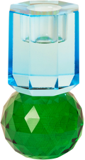 Ein hoher Kerzenhalter aus Glas in Dunkelgrün und Kobalt Kristall-Optik, bestehend aus mehreren geometrischen Flächen. Der Kerzenhalter hat eine moderne, facettierte Optik, die das Licht reflektiert