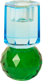 Ein hoher Kerzenhalter aus Glas in Dunkelgrün und Kobalt Kristall-Optik, bestehend aus mehreren geometrischen Flächen. Der Kerzenhalter hat eine moderne, facettierte Optik, die das Licht reflektiert