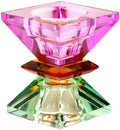 Ein hoher wendbarer Kerzenhalter aus Glas in Violett, Bernstein und Hellminze Kristall-Optik, bestehend aus mehreren geometrischen Flächen. Der Kerzenhalter hat eine moderne, facettierte Optik, die das Licht reflektiert, umgedreht