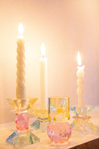 Verschiedene Kristallhalter mit Stabkerzen die angezündet sind