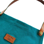 Petrol farbende Küchenschürze aus Baumwolle mit Bauchtasche und Leder-Träger