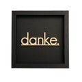 Quadratische dunkelgraue Wanddekoration mit der Schrift "Danke."