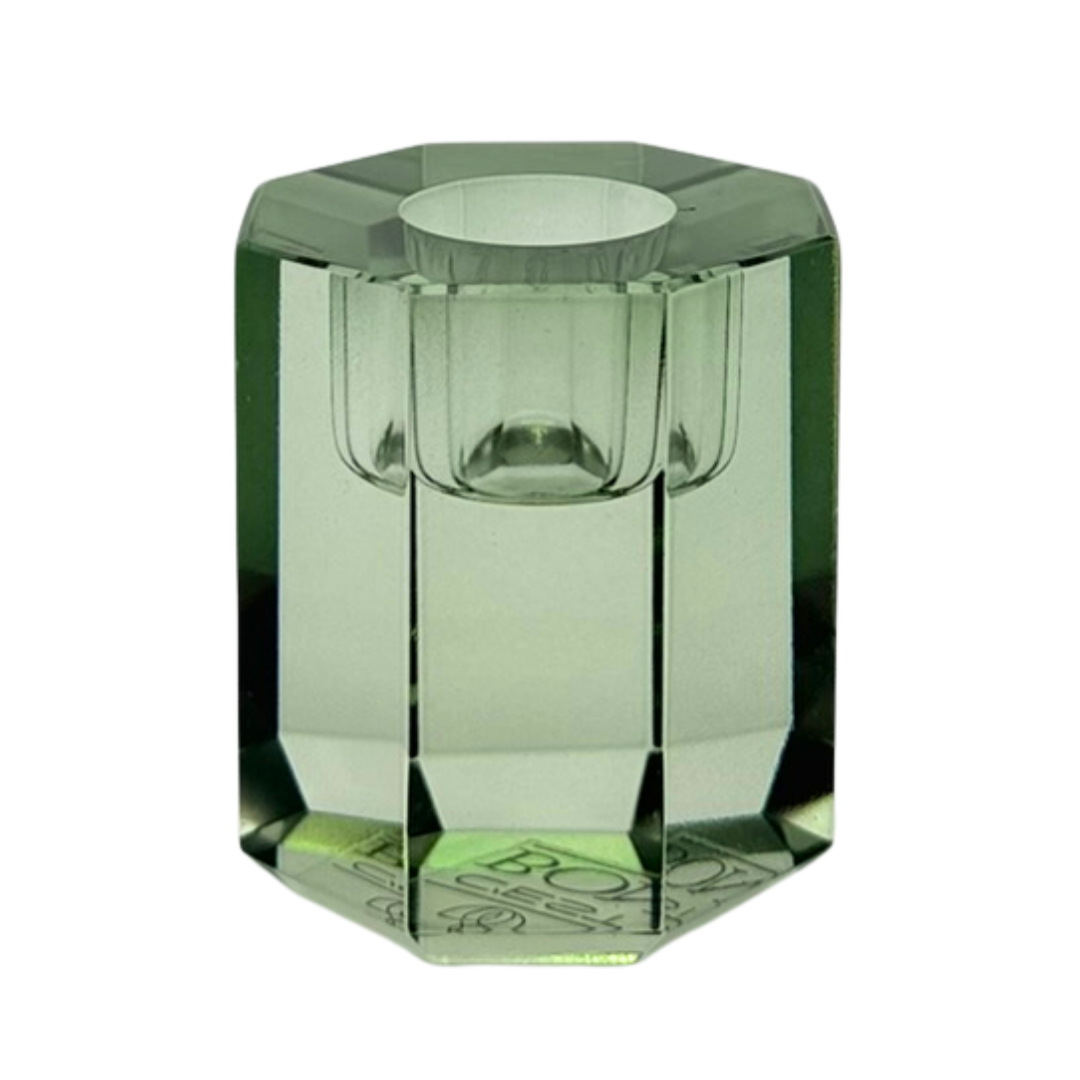 Ein niedriger Kerzenhalter in Olive Kristall-Optik, bestehend aus mehreren geometrischen Flächen. Der Kerzenhalter hat eine moderne, facettierte Optik, die das Licht reflektiert