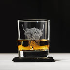 Whisky-Gläs mit aufgedruckten "Hochlandrind" Design, auf einem Tisch in dem Whisky gefüllt ist