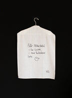 Das weiße Geschirrtuch mit der schwarzen Schrift "Bitte Abtrockenen: 1.Das Geschirr  2.Meine Freudentränen Danke." aufgehangen auf einem Bügel