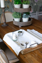 Das Baumwoll-Geschirrtuch mit goldfarbenem Huhn-Aufdruck zusammen auf einem Tablett mit Hühnereier, Besteck und Eierhalter