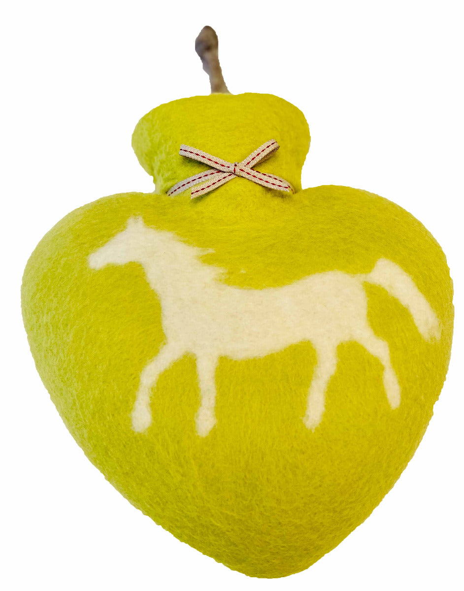 Eine herzförmige, limonfarbene Wärmeflasche mit einem Filzüberzug, auf dem ein weißes Pony abgebildet ist. Eine kleine Schleife ist am Flaschenhals gebunden