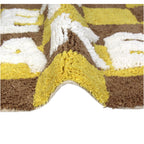 Badvorleger/ Badematte kariert in Braun und Gelb mit der weißen Schrift "Get naked" Nahaufnahme einer Wölbung