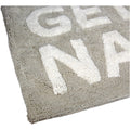 Taupe Badematte mit der weißen Schrift "Get Naked" Nahaufnahme einer Ecke