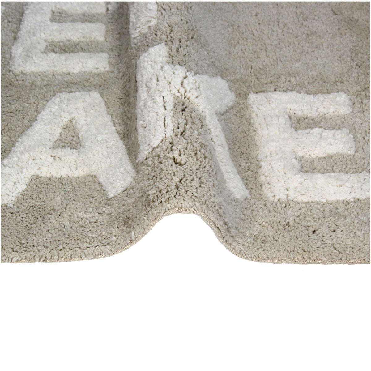 Taupe Badematte mit der weißen Schrift "Get Naked" Nahaufnahme eines teils gebogenen Badvorlegers