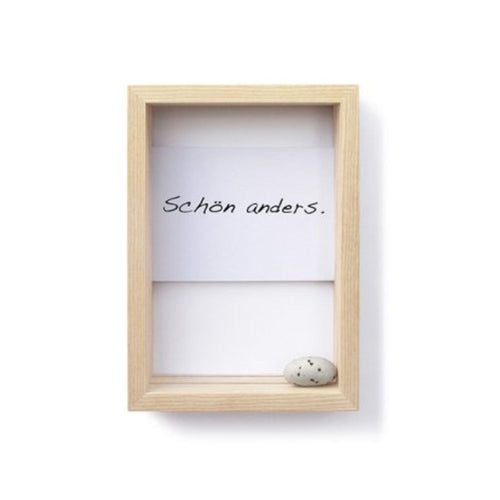 Rahmen aus Eschenholz für Postkarten, Karteikärtchen, Fotos, Urlaubserinnerungen. Hier mit einer weißen Postkarte mit der Schrift "Schön anders." und einem Steinchen