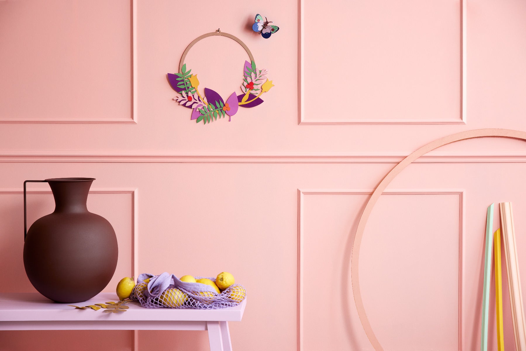 Die Wanddekoration Blütenkranz an einer Wand mit dem Schmetterling