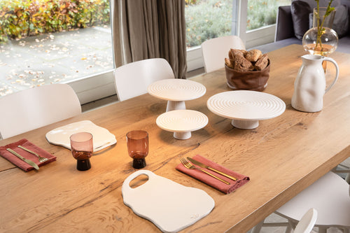 Weiße Designer Keramik Karaffe mit unebenen Flächen auf einem gedeckten Tisch
