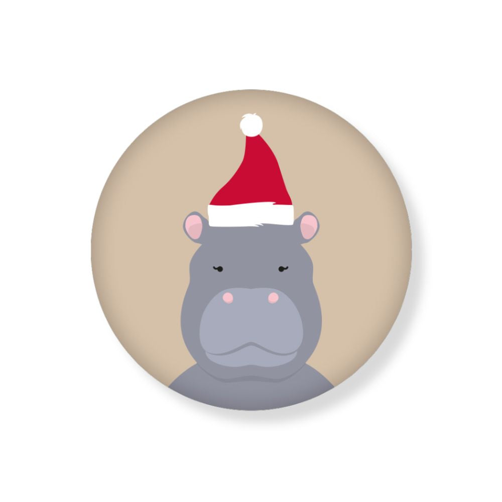 Runder Magnet mit beige hintergrund und einem nilpferd mit Weihnachtsmütze Motiv