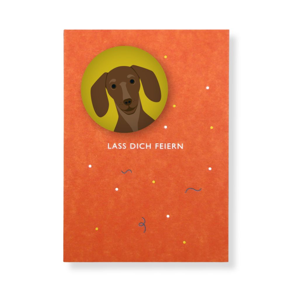 Orangene Postkarte mit Schrift "Lass dich feiern" mit gelbem Magnet mit Dackel Motiv