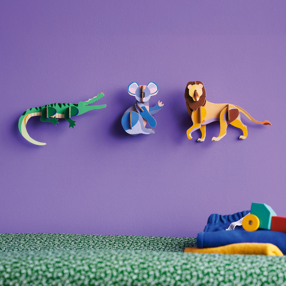mehere 3D Wanddekorationen an lilaner Wand befestigt, Koala, Krokodil und Löwe