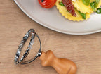Runder Ravioli-Ausstecher 6,5cm aus Edelstahl mit Holzgriff von Fackelmann auf einem Tisch neben einem teller