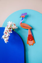 Das 3D Wandobjekt aufgehangen an einer Wand zusammen mit Orchideen