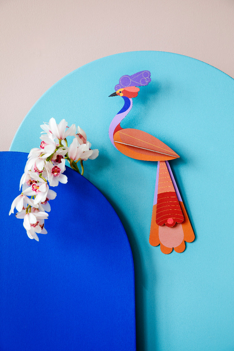 Das 3D Wandobjekt aufgehangen an einer Wand zusammen mit Orchideen