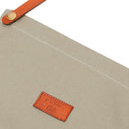 Nahaufnahme des Taupe farbigen Stoffs der Schürze und des Logos "Prime Cuts"