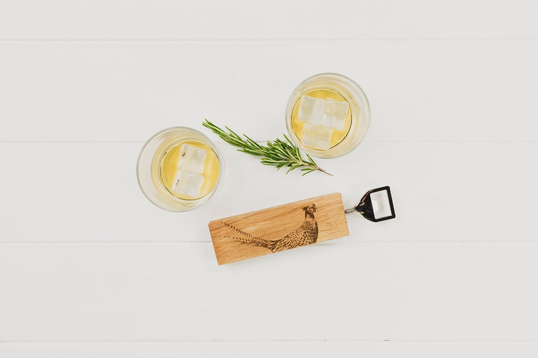 Ein Flaschenöffner mit einem rechteckigen Eichenholzgriff, auf dem ein Fasan-Motiv eingebrannt ist