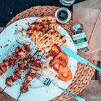 Mit der Wildkräutermischung gewürzes Essen und das Fläschchen daneben