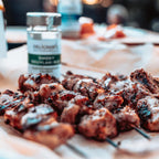 Mit der Wildkräutermischung gewürzes Fleisch und das Fläschchen daneben